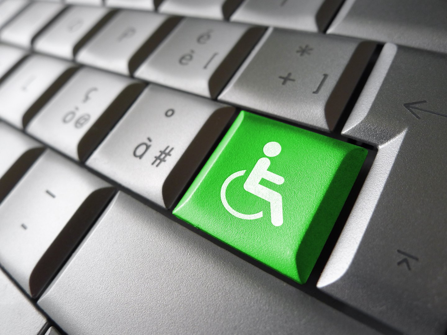Web content accessibility concept with wheelchair icon and symbol on a green computer key